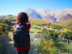 Backshot of a Cauvasian girl tourist admires the Vettore mountain in autumn in the sibillini park