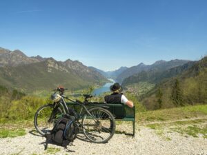 Italy, Lombardy, Senior hiker looking over Idro lake, Adamello Alps, Parco Naturale Adamello Brenta