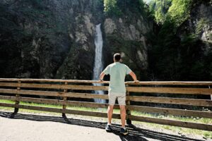 Back of man against waterfall in Liechtensteinklamm or Liechtenstein Gorge, Austria.