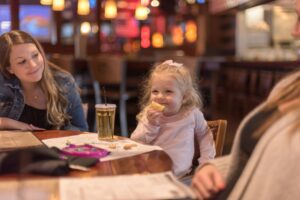 Happy people having dinner at a kid friendly restaurant