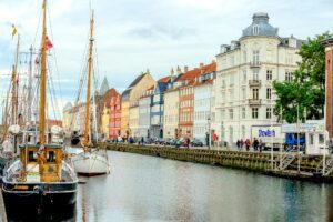 Scenic river view of vibrant buildings and boats in Copenhagen, Denmark.