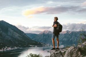 Traveler standing on a mountain and looking on evening the old town of Kotor, Montenegro