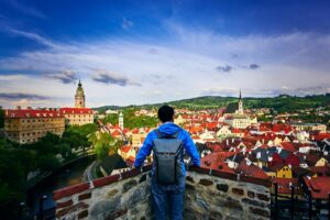 travelling man from behind is looking at the cityscape, old town of Cesky Krumlov, Czech Republic